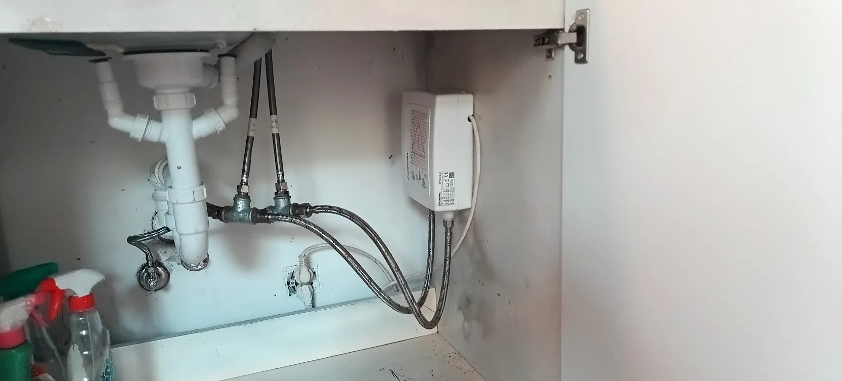 Podgrzewacz wody i podłączenie instalacji wodnej w szafce pod zlewem