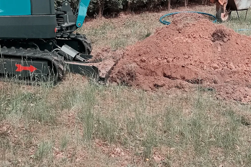 Minikoparka wykonująca wykop pod przyłącze wodne z rurą PE